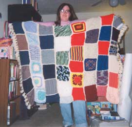 Image of the finished blanket from the first go-round, held by 
Suzanne/Segnbora-t